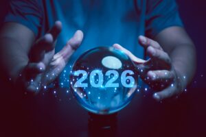 A pair of hands around a crystal ball that has the year 2026 written inside it.
