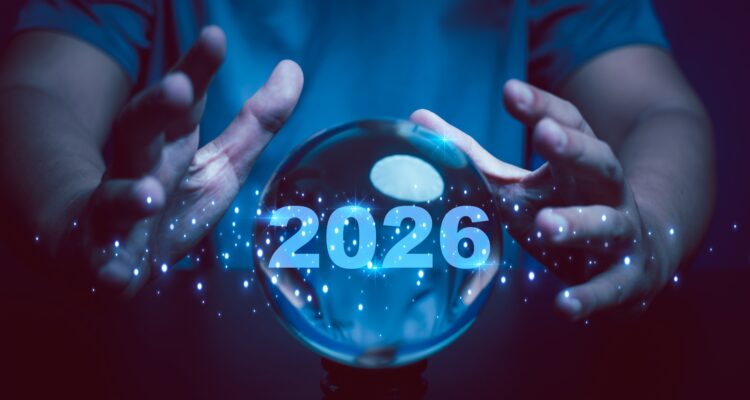 A pair of hands around a crystal ball that has the year 2026 written inside it.
